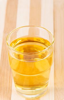 Apple juice in glass. On cutting board.