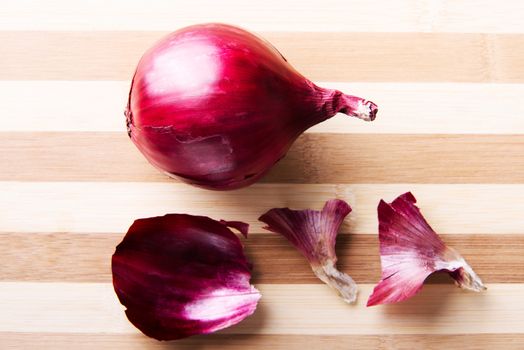 Red onion over wooden background.