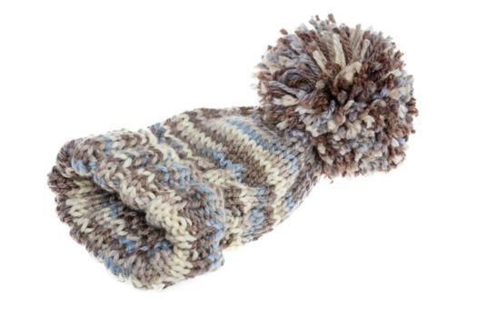 Warm woolly winter hat with a huge pompom hand-knitted from mottled grey wool on a white background