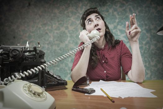 young Secretary smoking a cigarette while talking on the phone, 1960's scene