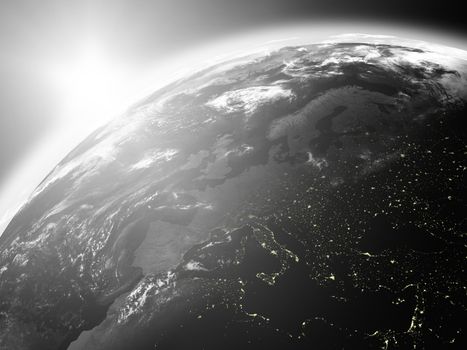 Space view of the sun rising over Europe on black planet Earth. Elements of this image furnished by NASA.