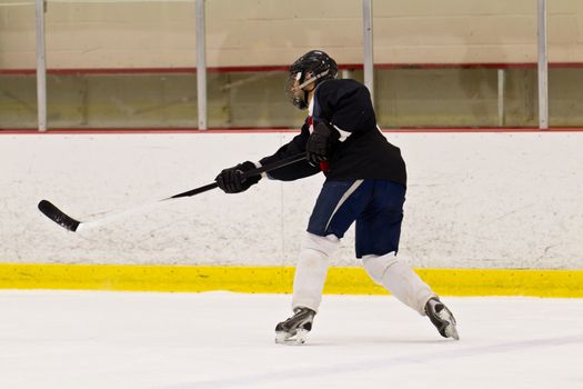 Hockey player takes a slap shot during a game