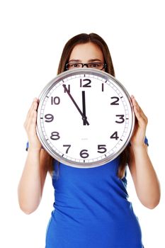 Young casual woman holding clock. Isolated on white.