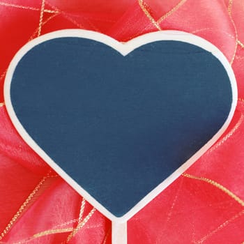 Heart shaped blackboard on red bow with copy space, retro filter effect