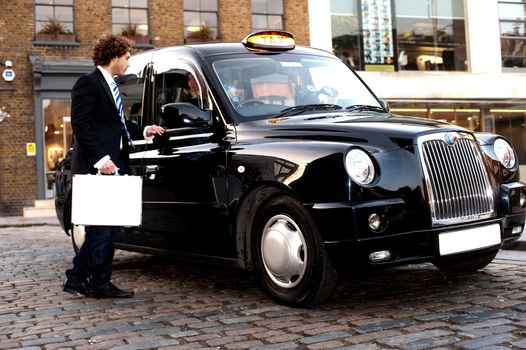 Taxi cab driver communicating with male passenger