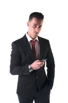 Good looking businessman sending or reading text message on his mobile phone