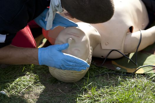 Instructor demonstrates how to check breathing on a dummy