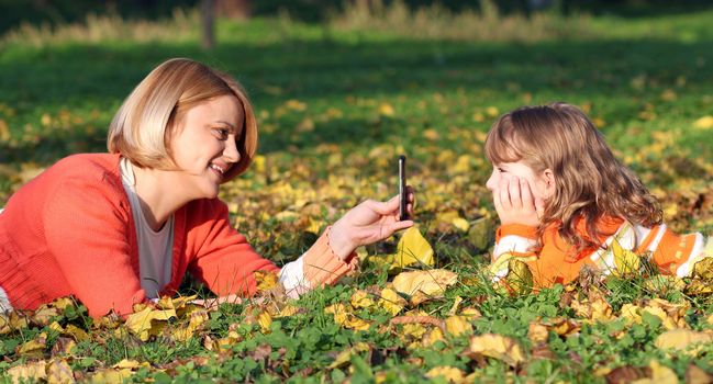 mother with smartphone take picture of daughter