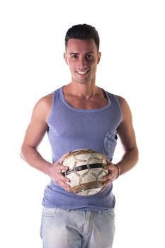 Smiling young man in tanktop holding soccer ball, looking at camera, isolated on white
