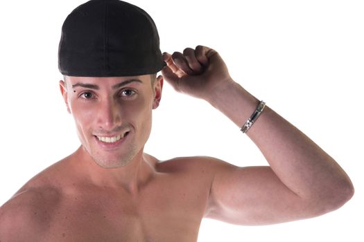 Shirtless young man smiling, touching his black baseball hat, isolated on white