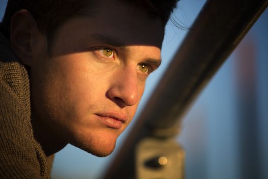 Headshot of handsome young man, lit by sunset light
