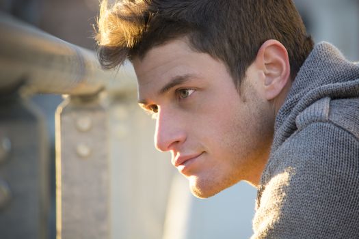 Headshot of handsome young man, lit by sunset light