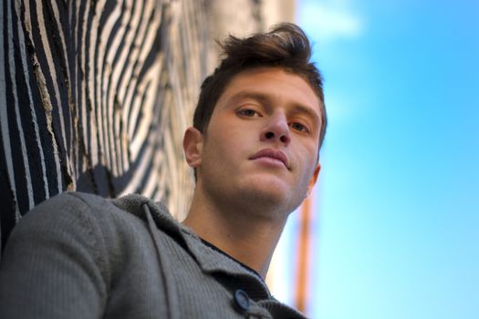 Handsome young man against zebra striped design in urban setting, looking at camera