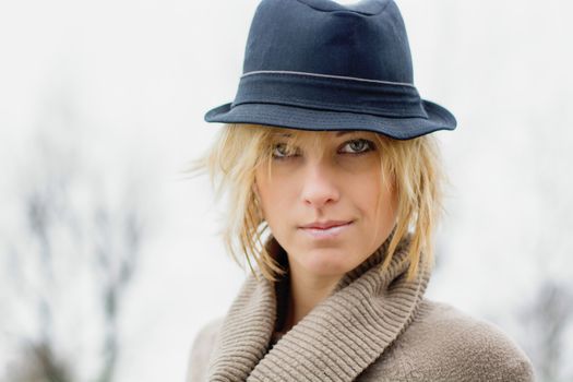 Pretty blonde girl with fedora hat, outdoors shot