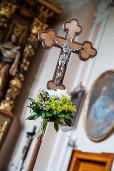 Cross with a flower bouquet in a Church