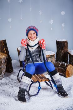 Winter Fashion. Adorable happy fashion girl in winter hat gloves and sweater in studio.