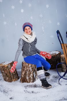 Winter Fashion. Adorable happy fashion girl in winter hat gloves and sweater in studio.