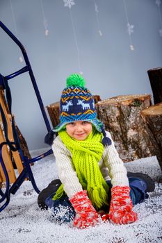 Winter Fashion. Adorable happy fashion boy in winter hat gloves and sweater in studio.
