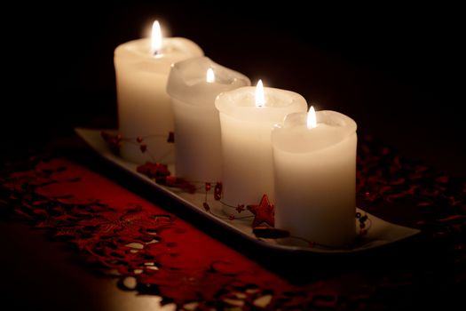 Burning candle and Christmas decorations on wooden table, on dark background