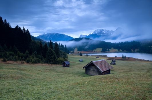 wooden hut and morning fog over Geroldsee lake, Bavarian Alps, Germany