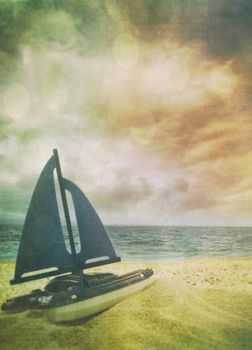 Toy sailboat in the sand with vintage look