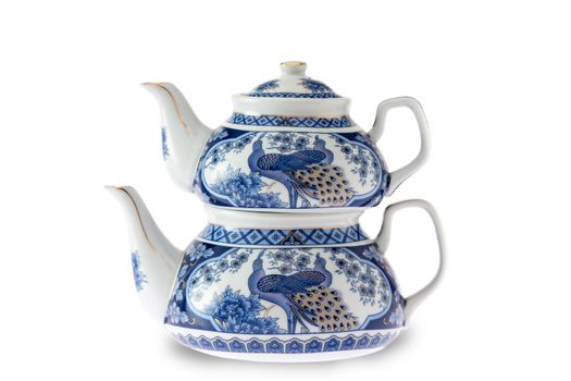 Antique pottery Turkish teapot with the traditional double stacked kettles decorated with a blue and white design depicting a peacock, over a white background