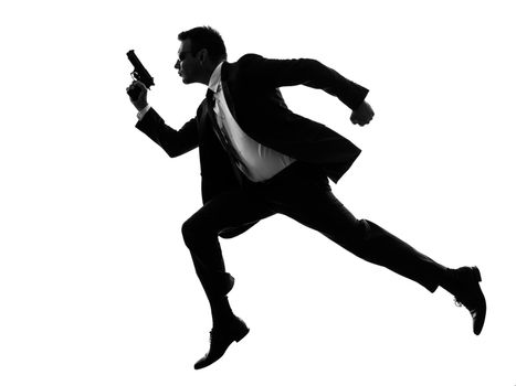 one caucasian man running with handgun  in silhouette  on white background