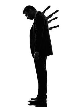 one caucasian business man Stabbed in the Back in silhouette  on white background