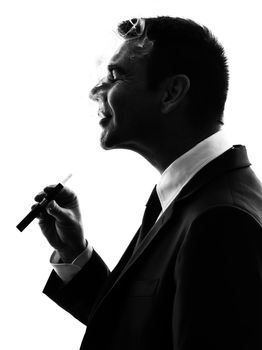 one caucasian business man smoking electronic e-cigarette  in silhouette  on white background