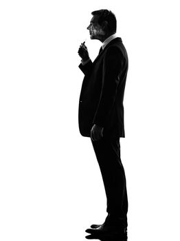 one caucasian business man smoking electronic e-cigarette  in silhouette  on white background
