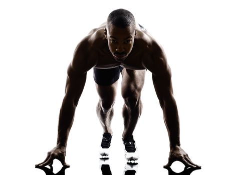 one young african muscular build man on starting blocks silhouette  isolated on white background