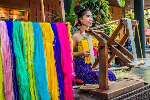 Bangkok, Thailand - December 28, 2013: woman spinning silk at Jim Thompson House museum in  Bangkok, Thailand on december 28th, 2013