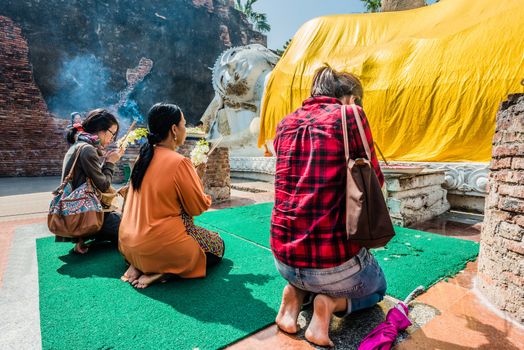 Bangkok, Thailand - December 29, 2013: people praying to the reclining buddha statue at Wat Yai Chaimongkol Ayutthaya in Bangkok, Thailand on december 29th, 2013