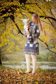 Mother walking with  baby in sling in the park