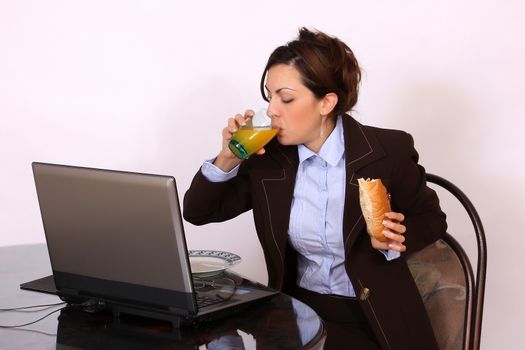 portrait of businesswoman eating by the desk