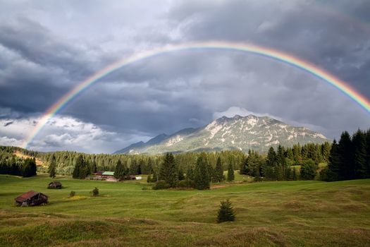 colorful rainbow over Karwendel Alps and meadows, Bavaria, Germany