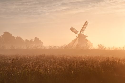 Dutch windmill in fog and morning sunshine, Groningen, Holland