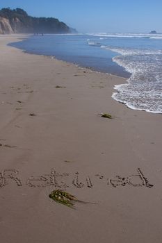 A beautiful image of a beach with the word "retired" written in the sand.