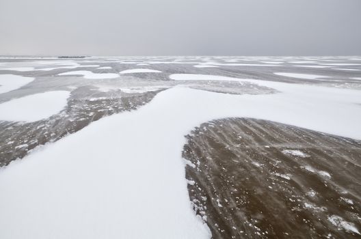 wind create snow texture on frozen lake Ijsselmeer, Netherlands in winter