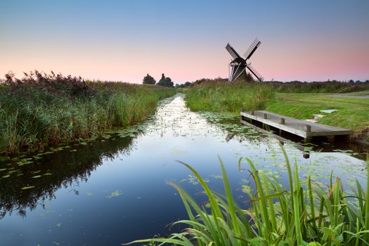 sunrise over river and Dutch windmill, Groningen, Netherlands