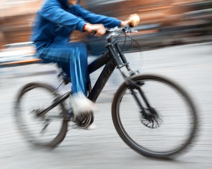 cyclist in traffic on the city roadway. Intentional motion blur