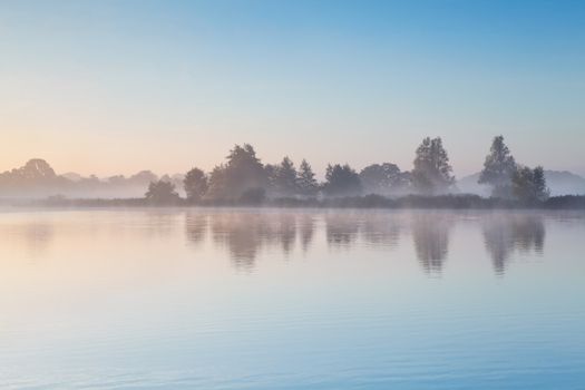 blue sky and morning fog over wild lake