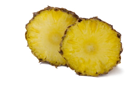 Two large slices of pineapple and two small slices. Presented on a white background.