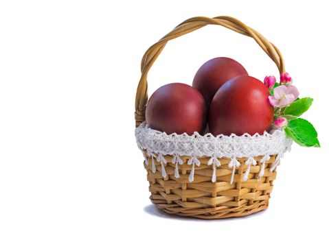 Three Easter eggs, painted in red, are beautifully decorated with wicker basket. Presented on a white background.