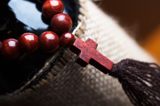 wooden rosary with a cross on a bottle of wine