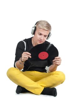 Young man reading from vinyl record and sitting on the floor