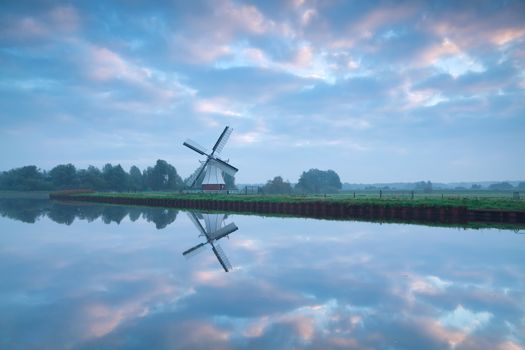 beautiful sunrise over river and windmill, Holland