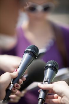 A journalist is making a interview with a microphone