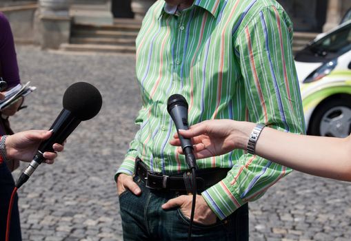 Interview with media microphone held in front of businessman, spokesman or politician