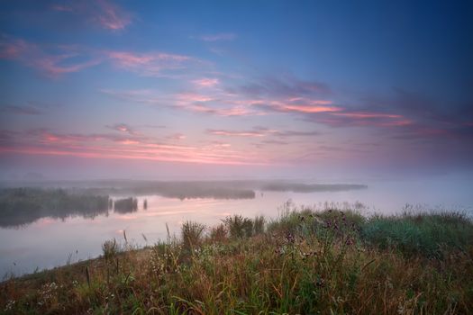 foggy sunrise over river in summer, Netherlands